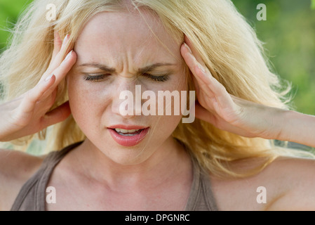 Donna con testa in mani Foto Stock