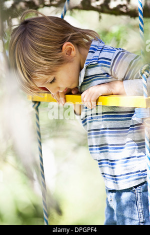 Little Boy permanente sulla swing Foto Stock