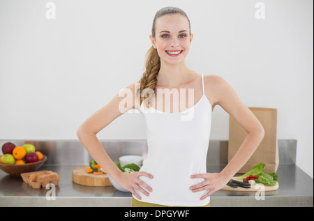 Bella Donna sorridente in piedi le mani sui fianchi Foto Stock