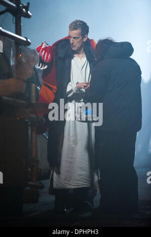 Cardiff, Galles, UK. Il 13 gennaio 2014. Peter Capaldi è macchiato sul set di medico che durante le riprese in un luogo pubblico (Mount Stuart Square, Cardiff Bay) per la prima volta nel suo nuovo ruolo come il dodicesimo medico. Egli è stato visto in sella ad un cavallo stunt tirata sul retro di un furgone, mentre una controfigura eseguita su un vero e proprio cavallo. Credito: Polly Thomas / Alamy Live News Foto Stock