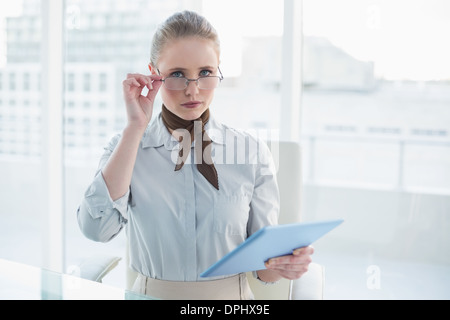 Bionda accigliata imprenditrice azienda tablet Foto Stock