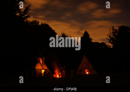 Lakota tende Tepee glow e il fuoco di notte a Wisconsin artista Ride Foto Stock