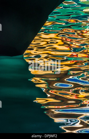 Ondulazione colorati motivi d'acqua. Riflessione e scafo del traghetto alla luce del tardo pomeriggio, attraccato a Circular Quay, Sydney Harbour, Australia Foto Stock