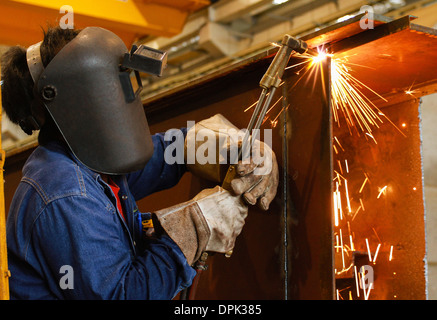 Lavoratore utilizzando la torcia taglierina per il taglio di metallo Foto Stock