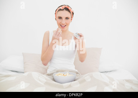 Sorridente giovane donna di guardare la televisione Foto Stock