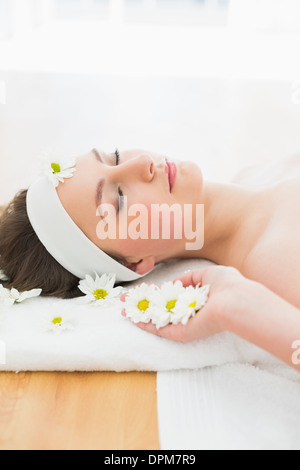 Bella donna con gli occhi chiusi sdraiato sul lettino da massaggio Foto Stock