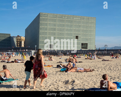Lucertole da mare e nuotatori sulla spiaggia Zurriola con centro congressi Kursaal e auditorium in background, San Sebastian, Spagna Foto Stock