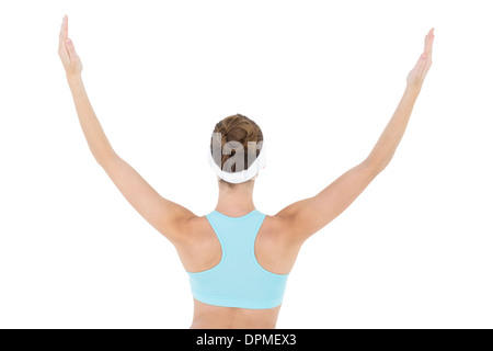 Vista posteriore di slim brunette donna che indossa abbigliamento sportivo alzando le braccia Foto Stock