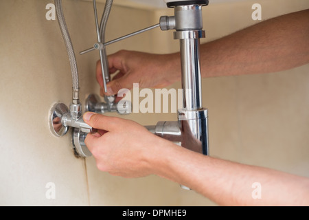 Extreme Close up di un mani per idraulici e di scarico lavabo Foto Stock