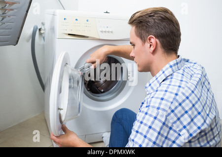 Il tecnico di riparazione di una macchina di lavaggio Foto Stock