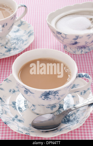 Tè inglese servita con il latte in un floreali servizio da tè Foto Stock