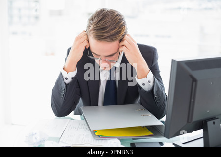 Imprenditore concentrato la lettura documento alla scrivania in ufficio Foto Stock