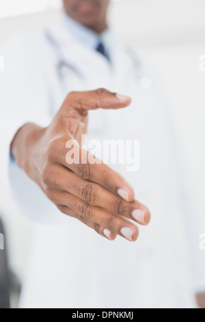 La sezione centrale del medico maschio offrendo una stretta di mano Foto Stock