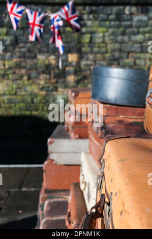 Unione Jack bunting appesa sopra il vecchio valigie impilati in una stazione ferroviaria di ricreare una scena tipica degli anni cinquanta e sessanta. Foto Stock