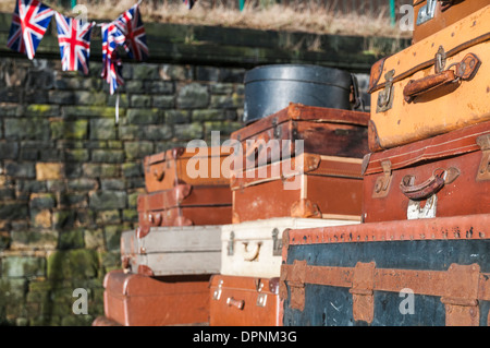 Unione Jack bunting appesa sopra il vecchio valigie impilati in una stazione ferroviaria di ricreare una scena tipica degli anni cinquanta e sessanta. Foto Stock