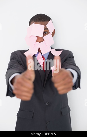 Imprenditore Afro contemplati nelle note vuote gesticolando pollice in alto Foto Stock