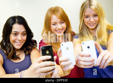 Tre ragazze adolescenti prendendo un selfie con i loro 3 iphone5 telefoni cellulari, Essex REGNO UNITO Foto Stock