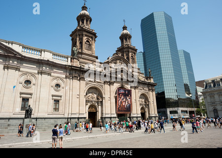 SANTIAGO, Cile: La facciata neoclassica della cattedrale metropolitana si erge in contrasto con i moderni edifici di vetro vicini lungo Plaza de Armas. La cattedrale, costruita tra il 1748 e il 1800, rappresenta l'architettura religiosa dell'epoca coloniale in mezzo all'evoluzione del paesaggio urbano di Santiago. Questa giustapposizione di architettura storica e contemporanea caratterizza la piazza centrale di Santiago. Foto Stock