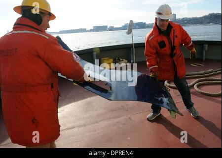Jan 21, 2009 - Manhattan, New York, Stati Uniti d'America - USACE deckhands Tom Scott e Danny Petrie (R) portano un pezzo di cofano dall'US Air volo. La NYPD unità Scuba recupera un pezzo della cofanatura, un coperchio per il motore dalla US Airways crash. La US Army Corpo degli Ingegneri barca M/V Hayward sulla scena nel fiume Hudson dove pensano che il motore mancante si trova da noi Airw Foto Stock