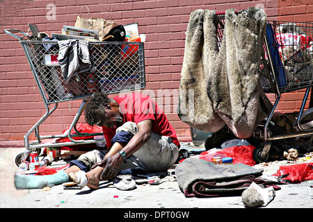 Maggio 06, 2009 - Los Angeles, California, Stati Uniti - Senzatetto pulisce i piedi vicino il suo carrello. Secondo l'Istituto per lo studio del fenomeno dei senzatetto e della povertà al centro Weingart, una stima di 254,000 uomini, donne e bambini l'esperienza dei senzatetto nella Contea di Los Angeles durante una parte dell'anno e circa 82.000 persone sono senza tetto in un qualsiasi dato di notte. I giovani non accompagnati Foto Stock