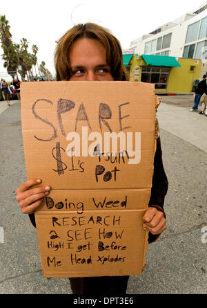 Mar 18, 2009 - Venezia, California, Stati Uniti d'America - Prestazioni artista, fire spinner e American bushman (come egli descrive il suo regime notturna) GEOPHREE NASON scherzosamente si nasconde dietro il suo segno di cartone sul Venice Boardwalk. Essere colpito fino a cambiamento di ricambio dei senzatetto è a malincuore ha accolto parte dell'esperienza sulla spiaggia per la folla di gente del posto e i turisti che affollano la Venic Foto Stock