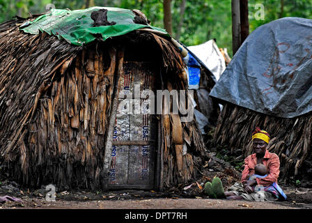 Mar 25, 2009 - Goma, NELLA REPUBBLICA DEMOCRATICA DEL CONGO - una donna e il suo bambino sedersi di fronte al loro rifugio in un campo di rifugiati al di fuori di Goma nella dilaniata dalla guerra del Congo orientale. La Repubblica Democratica del Congo è uno dell'Africa più grandi paesi, una lussureggiante ricoperta, sotto popolata nazione di circa 67 milioni di persone che vivono in un paese circa la dimensione dell'Europa occidentale..nel Nord Kivu e Sout Foto Stock