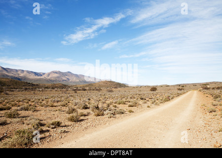 Strada sterrata in secca semi-regione desertica che conduce lontano dal visualizzatore Foto Stock