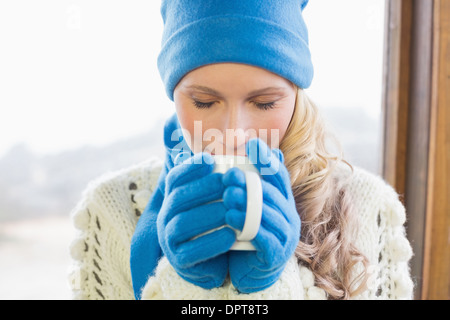 Carino donna di bere il caffè in un abbigliamento caldo Foto Stock