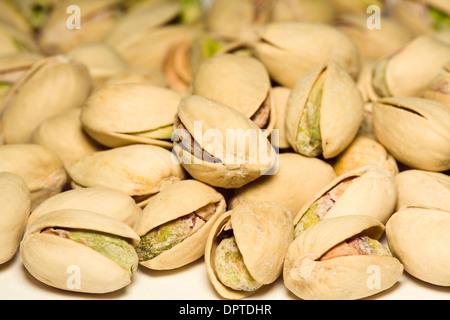 Tostati e salati di Pistacchi con guscio su sfondo bianco Foto Stock