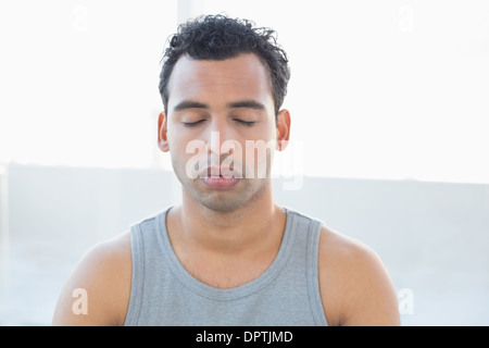 Close-up di un giovane uomo meditando con gli occhi chiusi Foto Stock