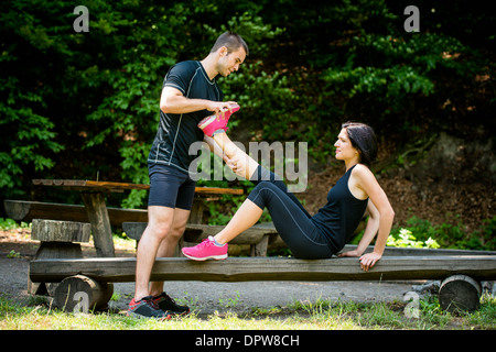 L uomo si allunga la gamba womans - spasmo muscolare dopo l'allenamento sportivo Foto Stock