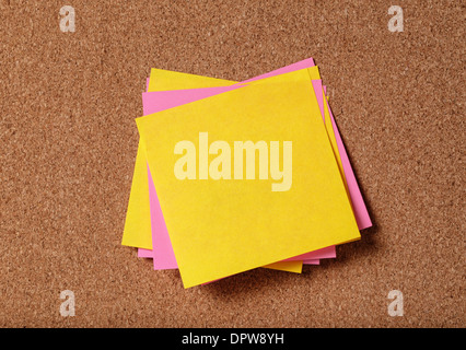 Mazzetto di vuoto sticky notes sulla bacheca di sughero Foto Stock