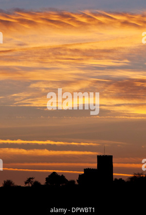 Il sole tramonta dietro la chiesa di St Mary e St Hardulph in Breedon sulla collina, Leicestershire Foto Stock