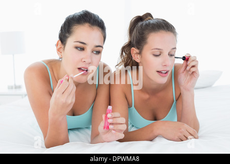 Amici di sesso femminile di applicare il make-up a letto Foto Stock