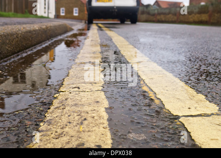 Doppie linee gialle e un furgone bianco parcheggiato illegalmente. Foto Stock