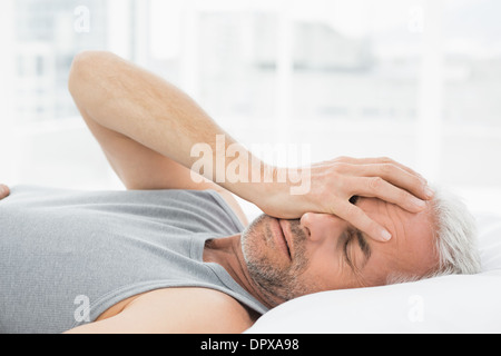 Uomo maturo dormire nel letto Foto Stock