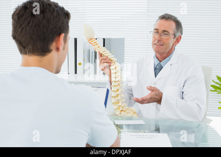 Medico spiegando la colonna vertebrale di un paziente in office Foto Stock