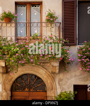 Fiori sul balcone sulla porta di casa in Piezna, Toscana, Italia Foto Stock