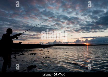 La pesca con la mosca su una festa di mezza estate della notte Foto Stock