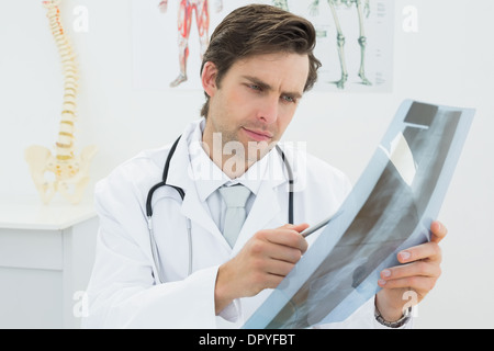 Concentrato medico maschio guardando a raggi x immagine della colonna vertebrale Foto Stock