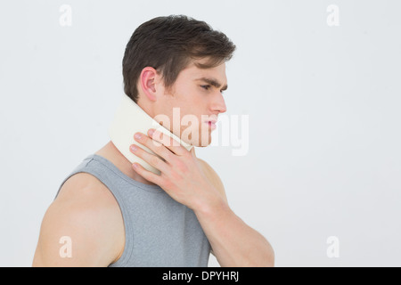 Vista laterale di un giovane uomo che indossa il collare cervicale Foto Stock