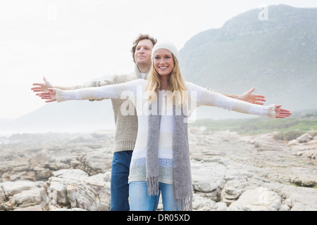 Casual giovane stretching mani sul paesaggio roccioso Foto Stock