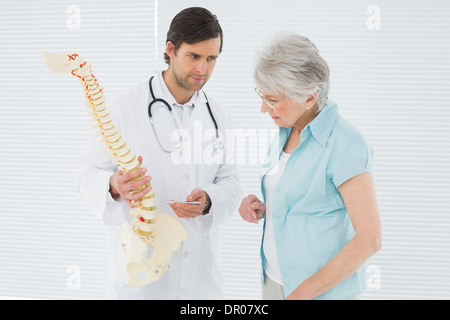 Medico spiegando la colonna vertebrale di un paziente senior Foto Stock