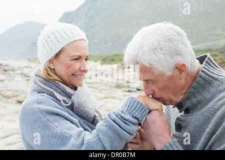 Senior baciare uomo donna felice la mano Foto Stock