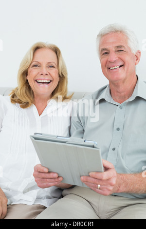 Coppia senior con tavoletta digitale in casa Foto Stock