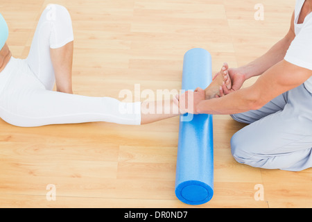 Fisioterapista esaminando una giovane donna è la gamba Foto Stock