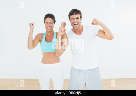 Montare allegro giovane clenching pugni in studio fitness Foto Stock