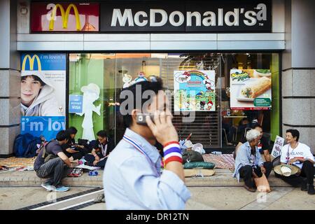 Bangkok, Tailandia. 15 gennaio, 2014. Un governo anti-protester cammina davanti a un ristorante fast food a uno di Bangkok rally principali siti nel quartiere dello shopping della citta'. Il blocco della capitale tailandese city è l'ultimo tentativo da realisti e la borghesia urbana per costringere il governo eletto di Yingluck Shinawattra. Credito: Thomas De Cian/NurPhoto/ZUMAPRESS.com/Alamy Live News Foto Stock