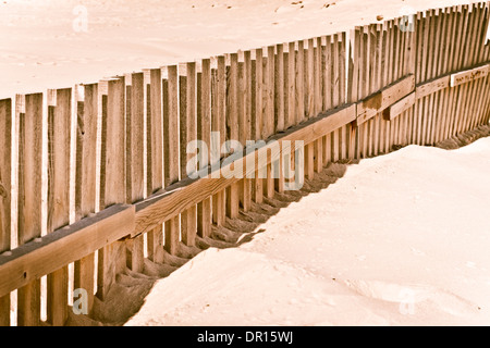 Staccionata in legno sulla spiaggia sabbiosa. Foto Stock