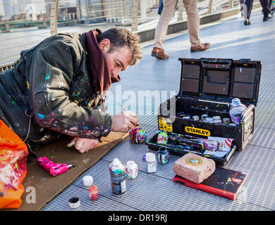 Londra, UK, 16 Gennaio 2014 . Artista, Ben Wilson, crea arte sul Millennium Bridge artista inglese è la pittura scartato la gomma da masticare macchie sul ponte e la miniatura di opere d'arte sono disegno folle di ammirando gli spettatori. Credito: Eden Breitz/Alamy Live News Foto Stock